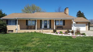 A two-story house with a front porch, a garage, and a well-maintained lawn. - BEST VALUE!! SPACIOUS Home! Short Walk to Beach! Many Amenities!! Great Reviews! (Rehoboth Beach)