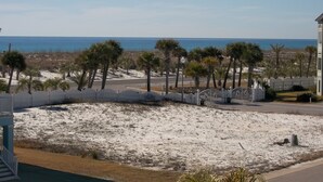 Blick auf die Küste mit einem Sandstrand, Palmen und blauem Himmel.