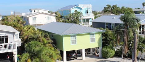 A residential area with houses, including a green house with a garage and a blue house with a balcony.