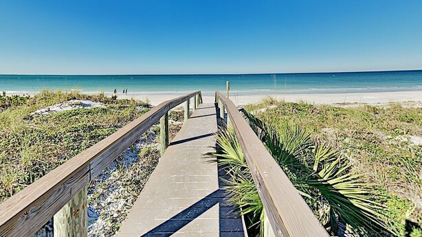 A wooden boardwalk leading to a beach with clear skies. - Pass-a-Grille Sunsets Are the Best! (st. pete Beach)