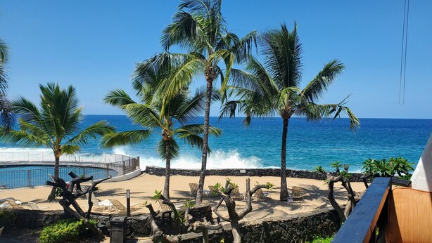 A beach with palm trees, a pool, and a view of the ocean. - Kitchen and Bath Remodel! - Ocean Front - Central Air - Featured on Today Show (Kailua-Kona)