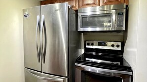 A compact kitchen with a stainless steel refrigerator, microwave, and oven. - Upgraded 3 BR condo on Pinehurst Course 3- walking distance to main club house (Pinehurst)