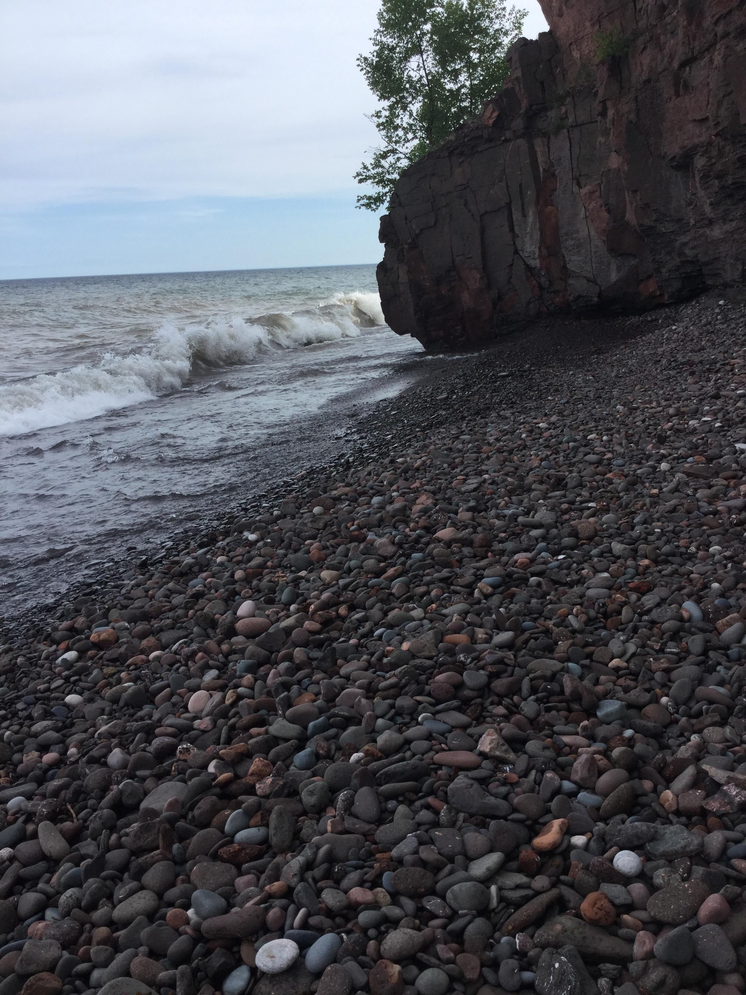 Une plage rocheuse où les vagues déferlent sur le rivage.