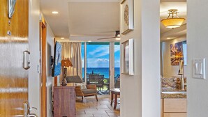 A hotel room with a view of the ocean, a dining area, and a kitchen. - Where Turtles and Sunsets Meet Kihei Oceanfront Condo Sweeping Ocean Views (Kihei)