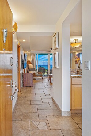 A hotel room with a view of the ocean, a dining area, and a kitchen. - Where Turtles and Sunsets Meet Kihei Oceanfront Condo Sweeping Ocean Views (Kihei)