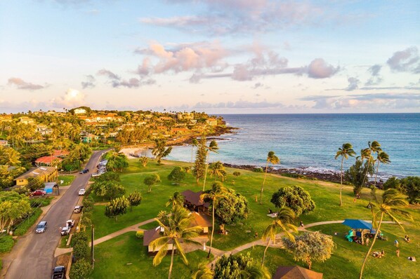 A coastal residential area with houses, a road, and a beach. - Regency Villas 120 - Luxury 3BR Poipu Kai Condo | Pool, Lanais & Central AC (Koloa)