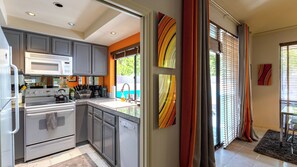A modern kitchen with grey cabinets, a white stove, and a built-in microwave.