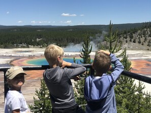 En grupp människor som betraktar ett geotermiskt område med färgstarka mineralavlagringar.