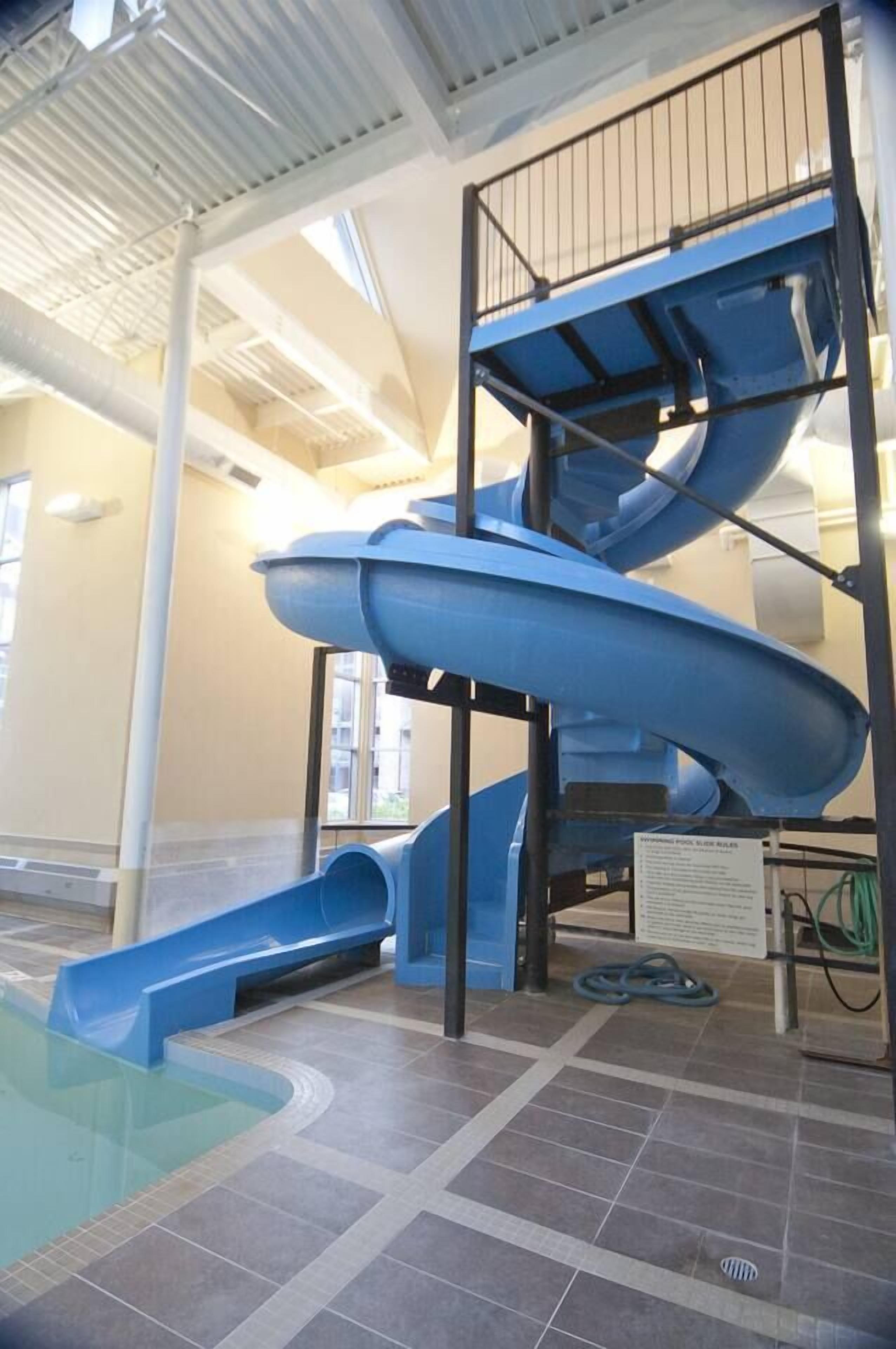 An indoor water slide with multiple levels and a pool at the bottom.