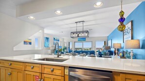A modern kitchen with a large island, stainless steel appliances, and wooden cabinets. - Touch of Paradise-Gulf Front Home Newly Renovated. Pup Friendly. Sleeps 12 (Navarre)