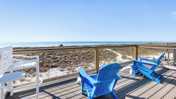 A deck with two blue Adirondack chairs and a white chair, overlooking a beach and dunes. - Touch of Paradise-Gulf Front Home Newly Renovated. Pup Friendly. Sleeps 12 (Navarre)