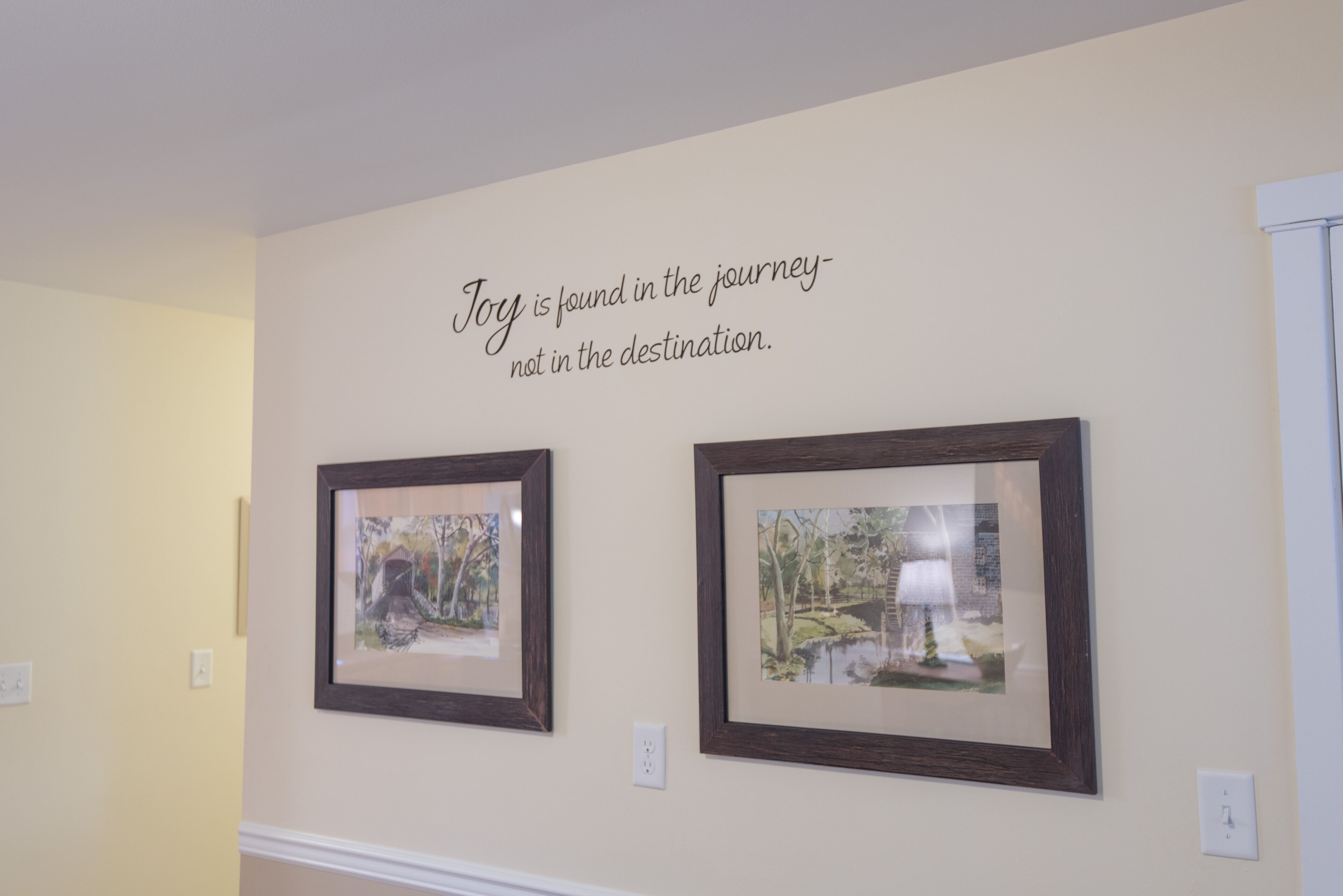 Un mur orné de deux tableaux encadrés et d’une citation inspirante.