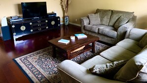 A living room with a sofa, a coffee table, a TV, a cabinet, and a rug. - Best North Napa Location, Close to Wineries & Restaurants (Napa)