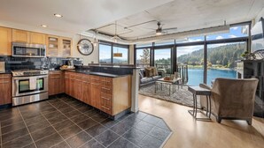 A modern kitchen with dark tiles, wooden cabinets, stainless steel appliances, and a large island. - NOW AVAILABLE FOR LABOR DAY! Coeur d’Alene Luxury Waterfront Condo (Coeur d'Alene)