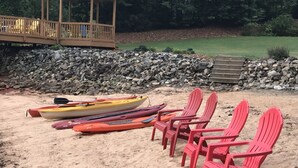 A sandy beach with kayaks and red chairs. - Luxury on Lake Keowee - FALL & Summer 2027 NOW OPEN (Seneca)