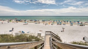 A beach with a wooden staircase leading down to the sand, umbrellas, and beachgoers. - GULF-FRONT, Cancellation, Balcony, Grill, Pool, Updated! (Santa Rosa Beach)