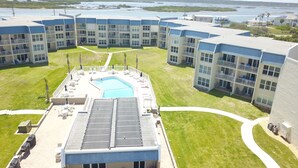 Ett hotell med en swimmingpool, flera balkonger och utsikt över vattnet.