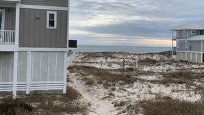 A beachfront property with a multi-story building, sandy beach, and ocean view.