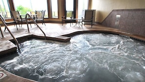A hot tub area with a pool, chairs, and a view of the outdoors. - Magnificent Water View Condo (Egg Harbor)