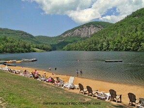 Relax by the serene lake at Sapphire Valley, where a sandy beach and dock await.