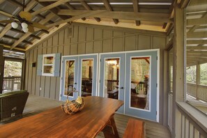 An enclosed porch with a wooden table and chairs, a woven basket, and a view of the outdoor deck. - 2Bd/1Ba ,opt'l +1Bd/1Ba, stream/waterfall/firepit, in Cashiers. Pet Friendly, (Cashiers)