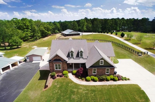 A two-story house with a sloped roof, a garage, and a well-maintained lawn.