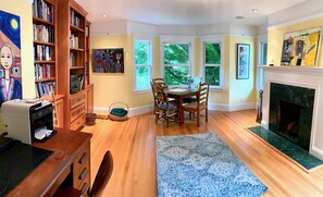 Cozy living room with a fireplace, dining area, and bookshelf.