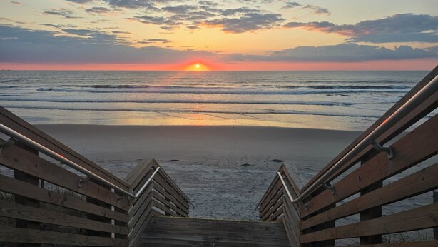 A wooden staircase leading to a beach with a sunset in the background. - Private Whalehead Beach Retreat - Pool, Hot Tub & 5-Minute Walk to the Ocean! (Corolla)