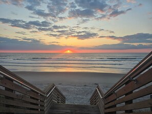 A wooden staircase leading to a beach with a sunset in the background. - Private Whalehead Beach Retreat - Pool, Hot Tub & 5-Minute Walk to the Ocean! (Corolla)