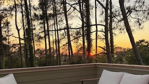A balcony with a sofa, chairs, and a round table. - Private Whalehead Beach Retreat - Pool, Hot Tub & 5-Minute Walk to the Ocean! (Corolla)