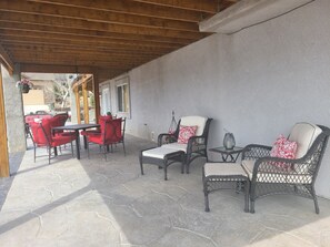 An outdoor patio with stone flooring, wicker furniture, and a wooden ceiling. - Lake Front, Rockies, Hiking, Mtn Biking! Aug. & Sept. Deals! (Monument)