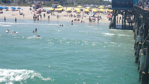 A beach with umbrellas, people, and a pier. - 5 BD, 3 bath, 200 Yards to Cocoa Beach (Cocoa Beach)