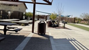 An outdoor patio area with a pergola, picnic tables, a trash can, and a mailbox. - Child, Handicapable, Senior friendly Newer 4 bedroom (Peoria)