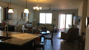 A spacious living area with a kitchen, dining table, and seating arrangements. - Child, Handicapable, Senior friendly Newer 4 bedroom (Peoria)