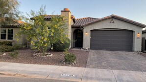 A residential house with a garage, a driveway, and a tree with yellow flowers. - Child, Handicapable, Senior friendly Newer 4 bedroom (Peoria)