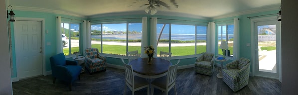 A sunroom with a curved glass wall, a dining table, and two chairs. - SPECTACULAR! PRIVATE POOL, OCEAN FRONT, & DOCK Sister house nextdoor VRBO#770357 (Marathon)