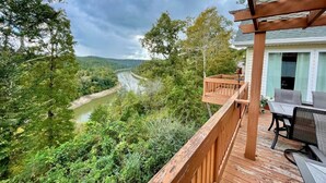 A wooden deck with a view of a river and forest. - Welcome to “Majestic View” – The View of a Lifetime! (Burnside)