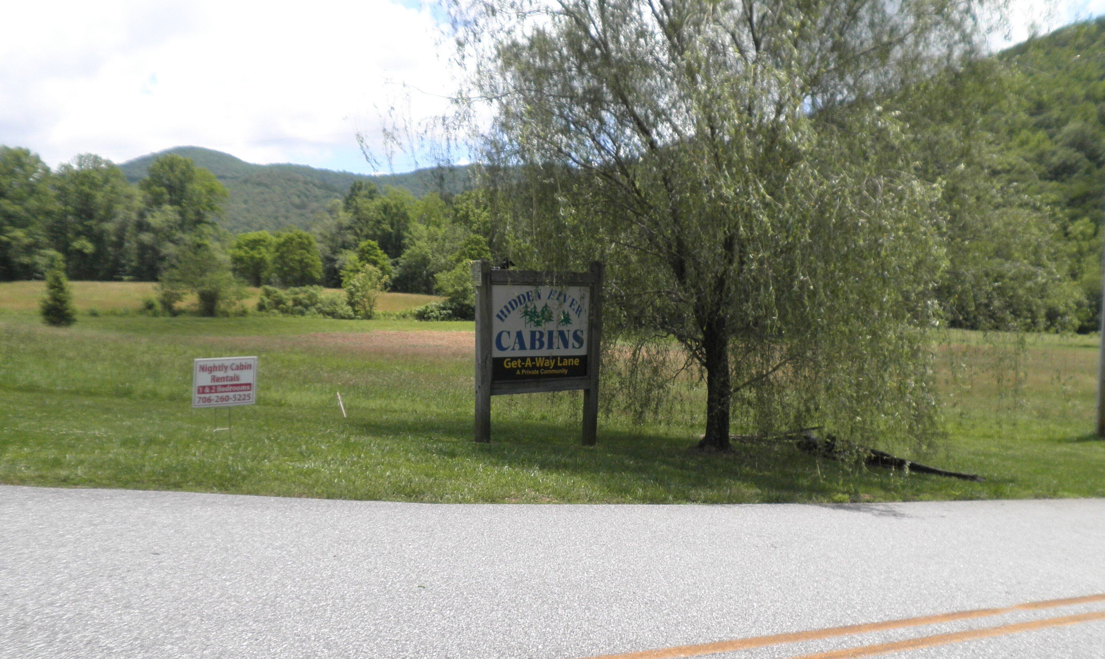 A sign for Hidden River Cabins Get-A-Way Lane, indicating a private community.