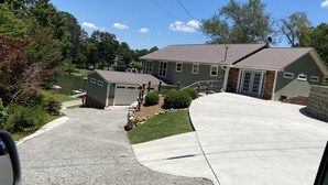 Une propriété résidentielle comprenant un garage, une allée couverte et un petit abri de jardin.