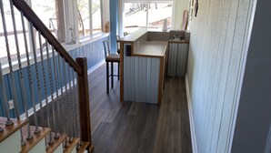 Une cuisine avec un îlot central en bois, une fenêtre et une porte portant l’inscription « Jimmy Buffett Drive ».
