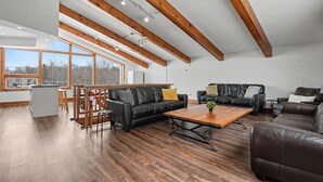 A spacious living area with a wooden ceiling, a dining area, and a kitchen. - Birch View Chalet Blue Mountain (The Blue Mountains)