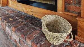 A brick fireplace with a wooden mantel and a woven basket on the hearth. - Birch View Chalet Blue Mountain (The Blue Mountains)