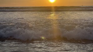 A sunset over the ocean with waves crashing onto the shore. - Casa Serena, Playa Grande. A private beachfront property! (Playa Grande)
