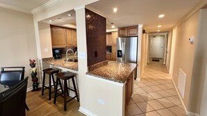 A modern kitchen with granite countertops, stainless steel appliances, and wooden cabinets. - Oceanfront Dream Vacation! 11th Floor-What a View!! + Beach Locker-Book Early! (Myrtle Beach)