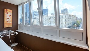 A room with a large window overlooking a cityscape, a white radiator, and a wall-mounted drying rack. - Clean, Safe and Affordable (Pechers'kyi district)
