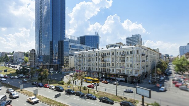 A cityscape with modern and historic buildings, a busy street with cars, and a clear sky. - Clean, Safe and Affordable (Pechers'kyi district)
