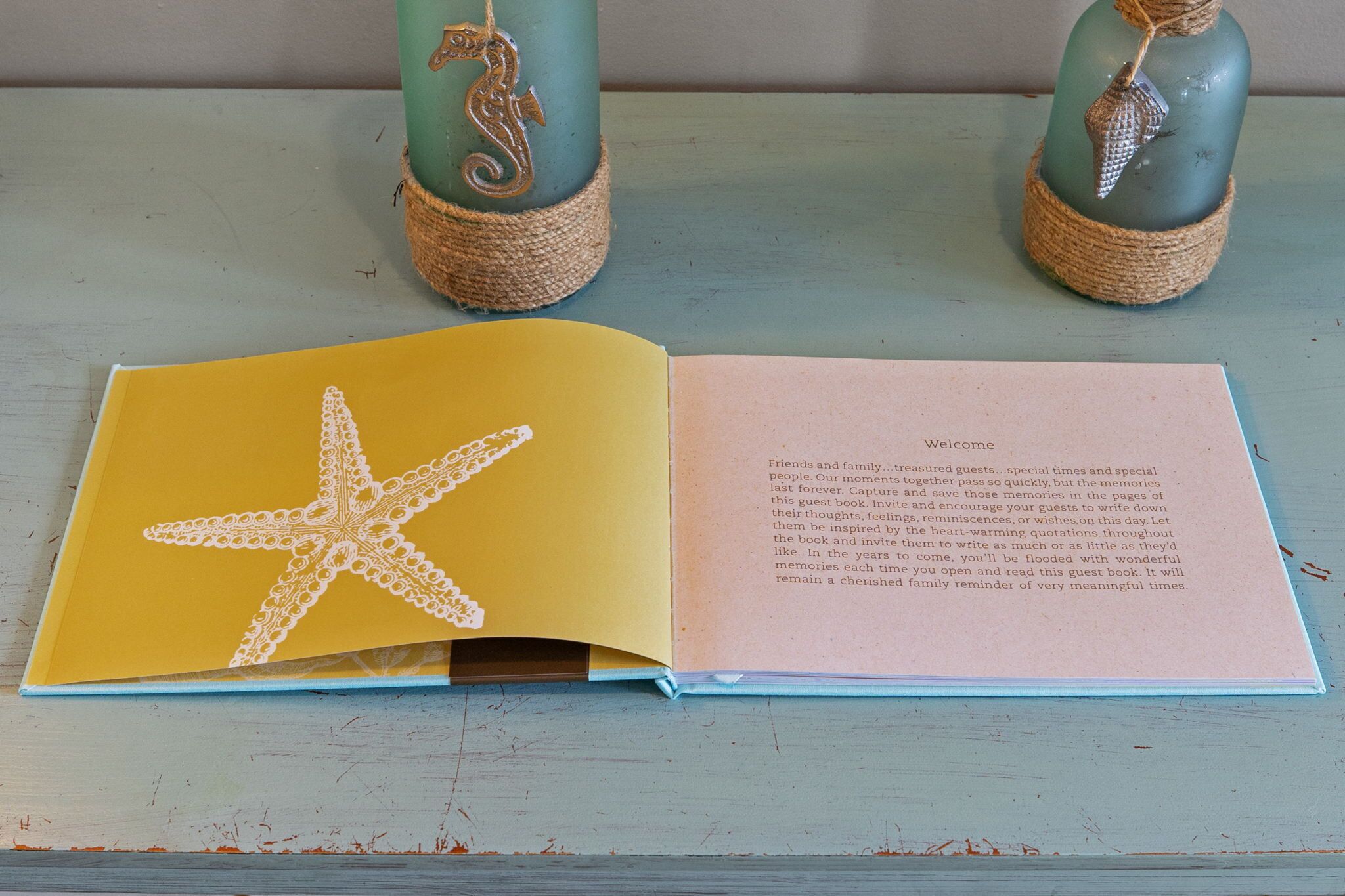 An open book with a yellow page featuring a white starfish design and a pink page with text.