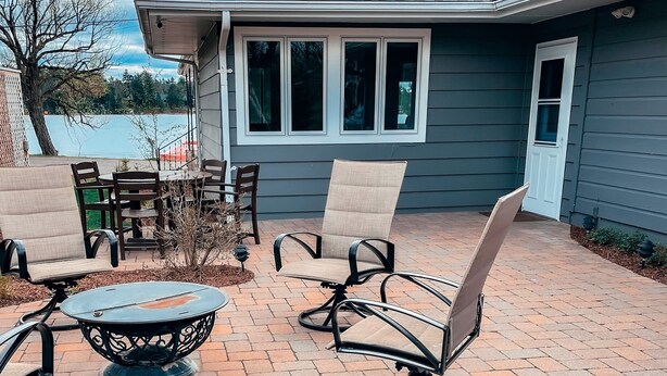 Un patio con mobiliario exterior, una mesa redonda y una silla.