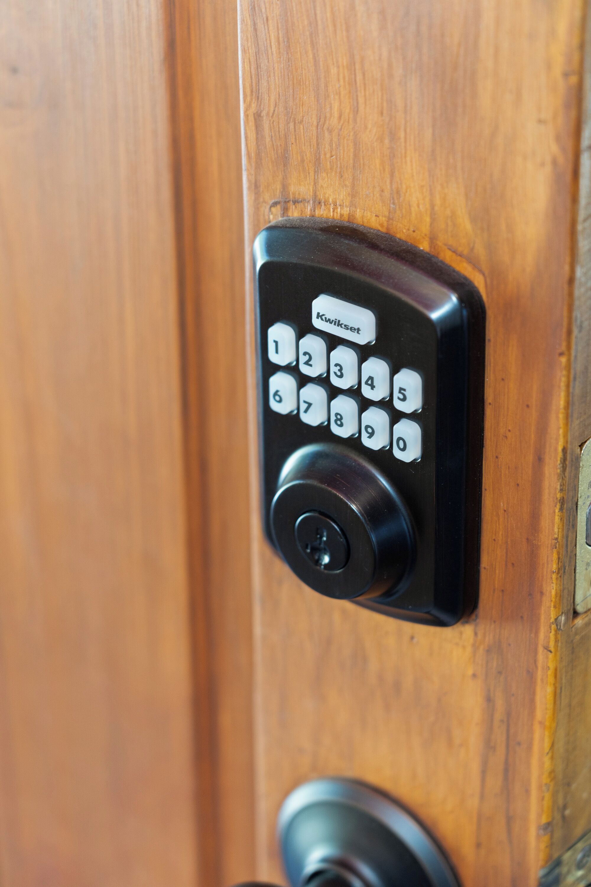 A numeric keypad lock on a wooden door.