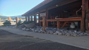 A rustic building with a 'CAMPING ONLY' sign, wooden beams, and a stone-paved entrance.